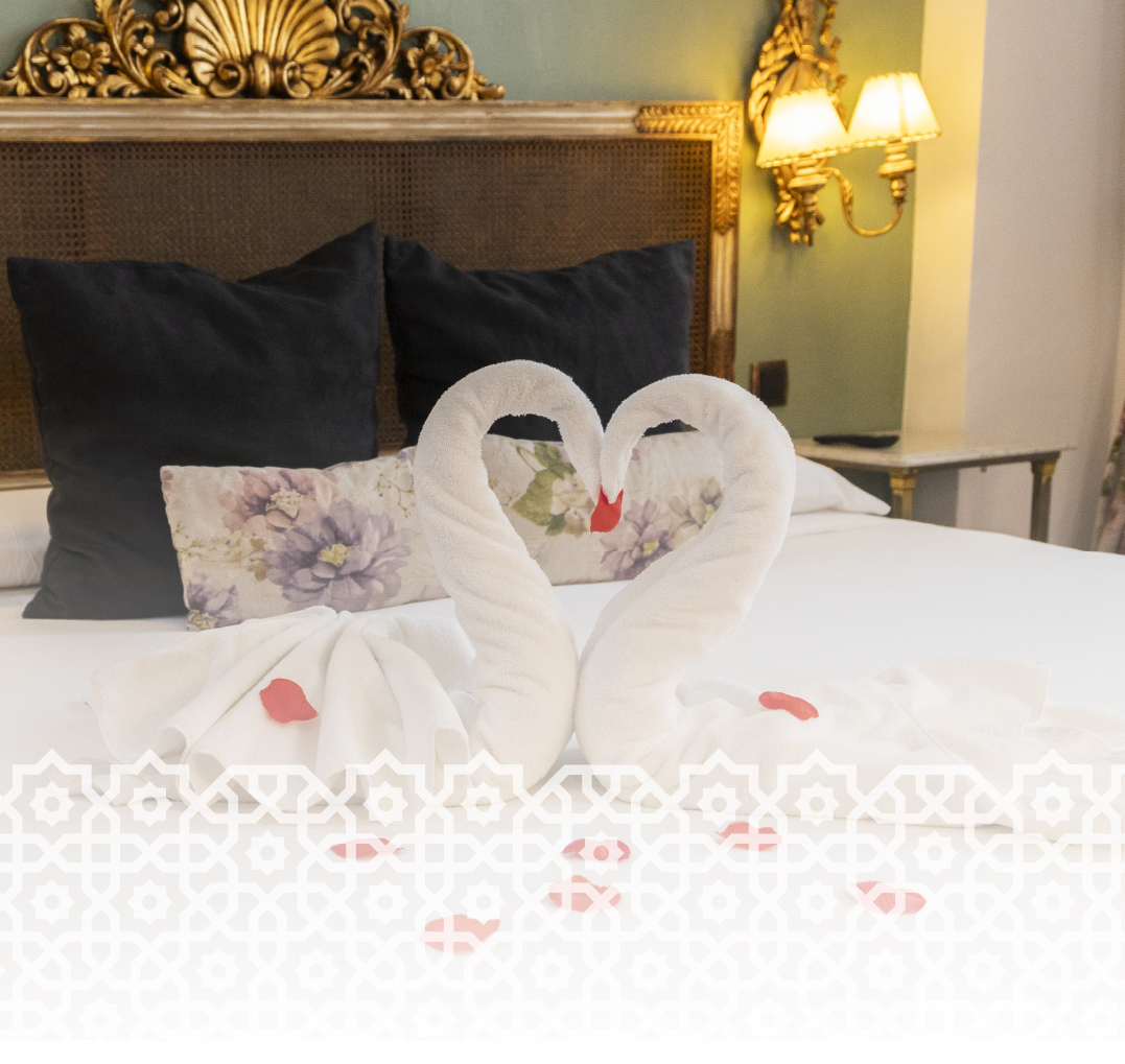 Toallas en forma de cisne encima de la cama